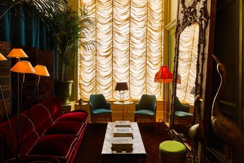 a living room with a couch and chairs and a table at The Siren Hotel in Detroit