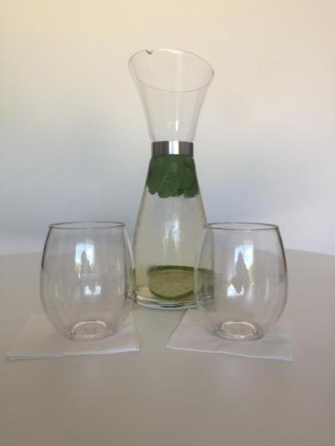 un vaso e due bicchieri seduti su un tavolo di Les Tignoliers a Tignieu-Jameyzieu