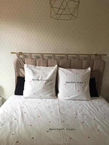 a white bed with four pillows on it at Les Tignoliers in Tignieu-Jameyzieu
