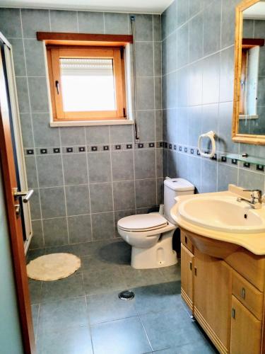 a bathroom with a toilet and a sink at Casa Avó Rosa in Nazaré