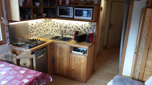 a small kitchen with a sink and a stove at Joli petit appartement cosi 5 personnes maxi plein centre station les deux alpes in Les Deux Alpes