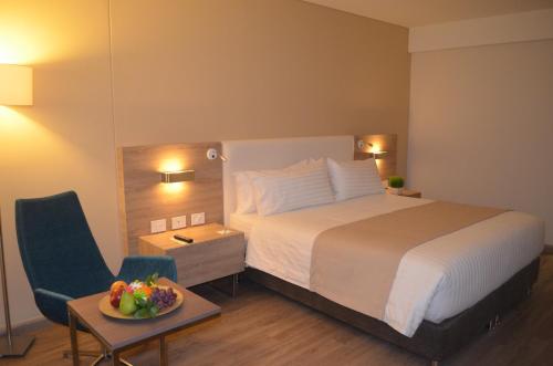 a hotel room with a bed and a table with a bowl of fruit at Holiday Inn Cúcuta by IHG in Cúcuta
