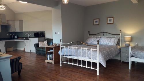 a bedroom with a white bed and a kitchen at The Croft in Sedgefield