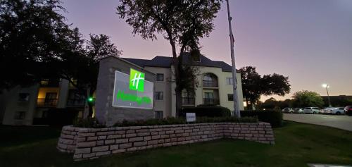 a house with a sign in front of it at Holiday Inn Irving Las Colinas, an IHG Hotel in Irving