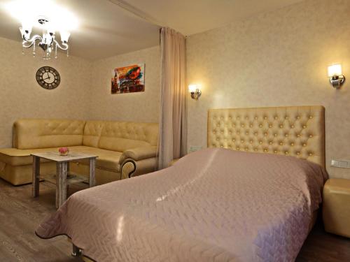 a bedroom with a bed and a couch and a table at ApartLux 3 in Chernihiv