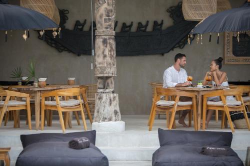 a man and woman sitting at a table in a restaurant at Karma Resort in Bophut 