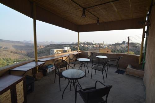 a balcony with tables and chairs and a view at Basmat almisfah in Al Ḩamrāʼ