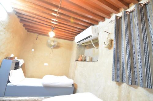 a room with two beds and a window at Basmat almisfah in Al Ḩamrāʼ