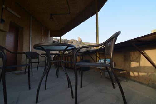 a group of chairs and tables on a balcony at Basmat almisfah in Al Ḩamrāʼ