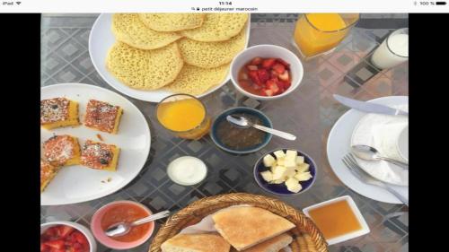 a table topped with plates of breakfast foods and drinks at Riad L'Artiste in Fès
