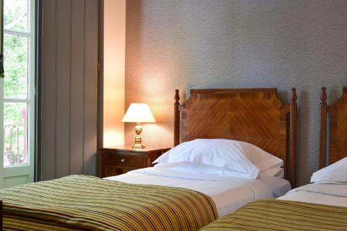 a bedroom with two beds and a lamp on a table at Central Monchique Hotel - Villa Termal Spa Resort - by Unlock Hotels in Monchique