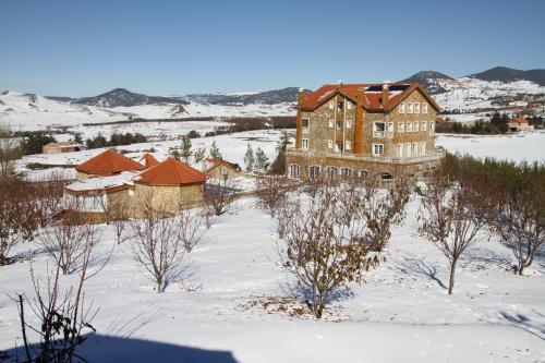 a large building in the snow with trees and buildings at Le Palais des Cerisiers in Azrou