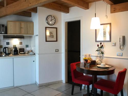 a kitchen with a table and a clock on the wall at La casa nel sole - Boutique B&B in Bari