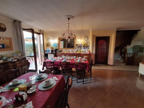 uma sala de jantar com mesas e cadeiras vermelhas e uma cozinha em B&B L'Isola di Casa em Brembate