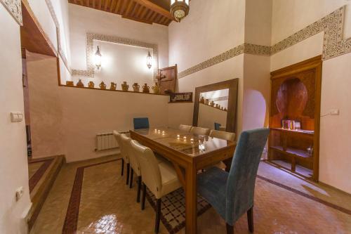 Un comedor con mesa y sillas de madera. en Riad Said, en Fez