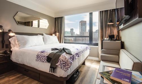 a hotel room with a bed and a large window at Pestana Park Avenue in New York