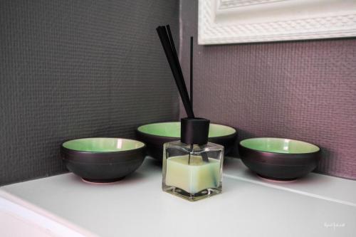 three bowls and a vase with candles on a counter at L'Xpérience in Valgorge