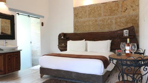 a bedroom with a bed and a table and a sink at Casa Hotel Santa Helena Boutique in Villa de Leyva