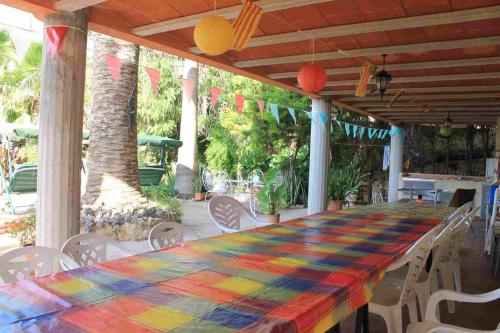 a table with a colorful table cloth on a patio at Casa Rural COMPLEX MASIA DEL TREMENDO y Agroturismo in Camarles