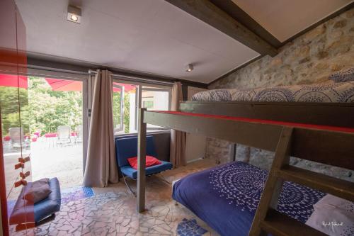 a bedroom with a bunk bed and a window at L'Xpérience in Valgorge