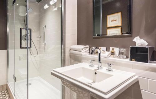 a bathroom with a sink and a shower at The Lygon Arms - an Iconic Luxury Hotel in Broadway