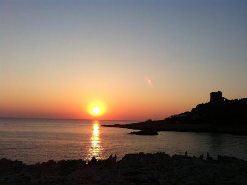 a sunset over the ocean with the sun setting at Agriturismo Mele in Copertino
