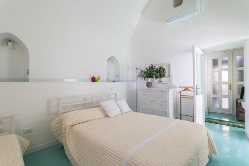 アマルフィにあるCasa Novellaの白いベッドルーム(ベッド2台付)、キッチンが備わります。
