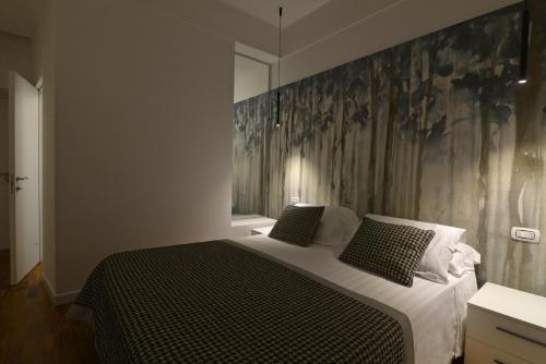 a bedroom with a bed with a large painting on the wall at San Domenico's Rooms in Matera
