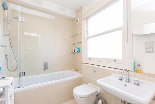 a bathroom with a toilet and a sink and a shower at 1-bed flat at the heart of Fulham & Parsons Green! in London