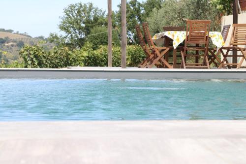 a pool of water with chairs and a table at Agriturismo Casale Contessa in Montebuono