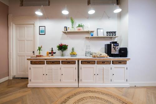 a kitchen with white cabinets and a counter at Stadsvilla Mout Rotterdam-Schiedam in Schiedam