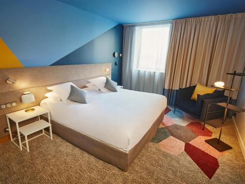 ボルドーにあるRadisson Hôtel Bordeaux Saint-Jeanの大きな白いベッドと椅子のある寝室