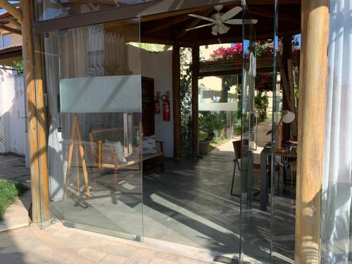 a glass doorway to a patio with a table and chairs at Loft Solar Água in Pipa