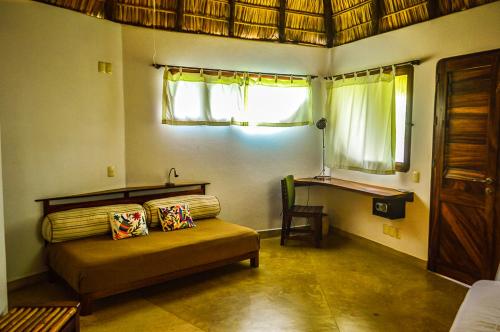 a bedroom with a bed and a window and a table at OceanoMar in Mazunte
