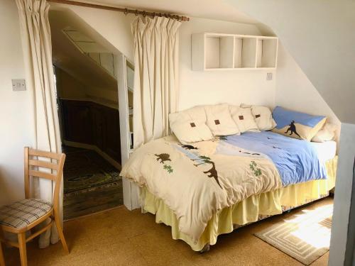 a bedroom with a bed and a chair in a room at Lauras Townhouse Apartments Skylight Loft in Bath