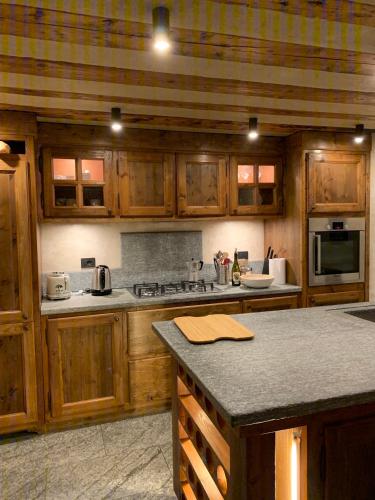 a kitchen with wooden cabinets and a counter top at Il Cuore della Valdigne - Courmayeur-La Thuile- Pré Saint Didier in Morgex