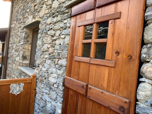 a wooden door on the side of a stone building at Il Cuore della Valdigne - Courmayeur-La Thuile- Pré Saint Didier in Morgex