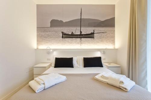 a bedroom with a bed with a picture of a boat at RelaisApartments PORTO in Alghero