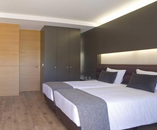 two beds in a hotel room with white sheets at Gare da Fonte Nova - Aveiro in Aveiro