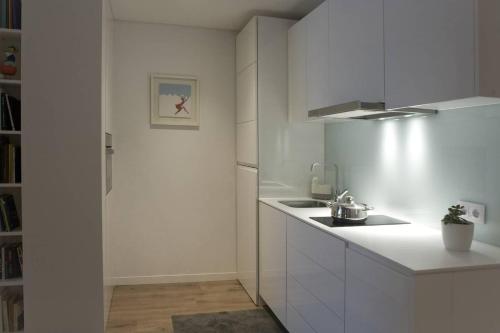 a white kitchen with a sink and a refrigerator at Gare da Fonte Nova - Aveiro in Aveiro