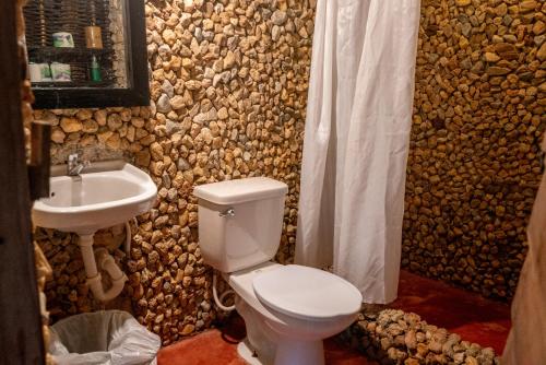 a bathroom with a white toilet and a sink at Dominican Tree House Village in El Valle