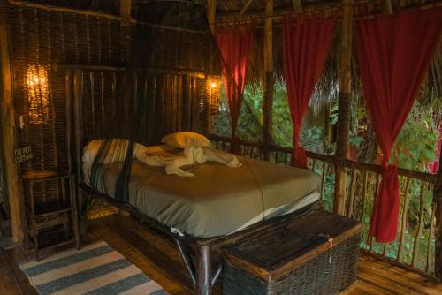 ein Schlafzimmer mit einem Bett in einem Zimmer mit einem Fenster in der Unterkunft Dominican Tree House Village in El Valle