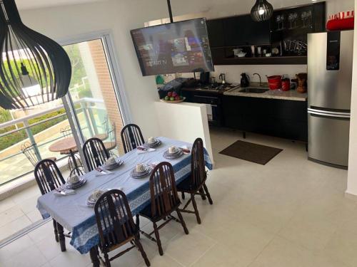 a kitchen with a blue table with chairs and a refrigerator at Apartamento Familiar Guaruja in Guarujá