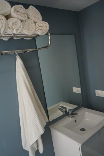 a bathroom with a sink and a mirror and a towel at Pescadors Apartamentos by TRG in Benidorm