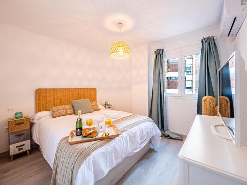 Un dormitorio con una cama con una bandeja de comida. en PREMIUM BEACH DESIGN - La Malagueta en Málaga