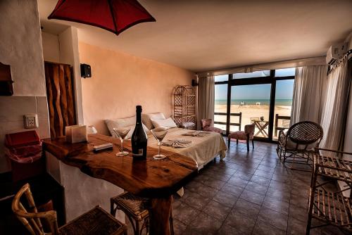 Habitación con cama y mesa con copas de vino en Rincón del Mar Apart Hotel, Spa & Resort en Las Gaviotas