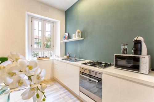 a kitchen with a sink and a stove top oven at RelaisApartments PORTO in Alghero