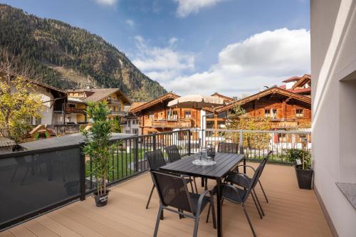 a balcony with a table and chairs on a deck at AlpenLiving in Mayrhofen