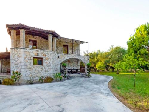 a large stone house with a driveway at Rouveli Villa with private garden and barbeque in Tragaki