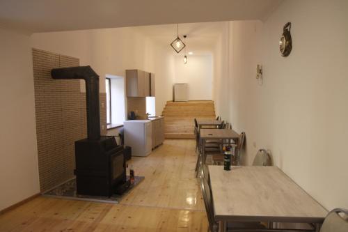 a room with tables and chairs and a stove at Eka's guest house in Mestia
